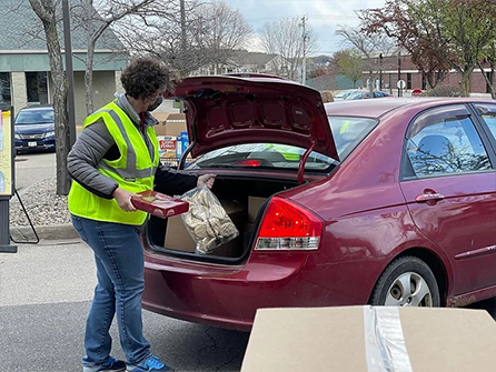 Volunteer loading food in a car